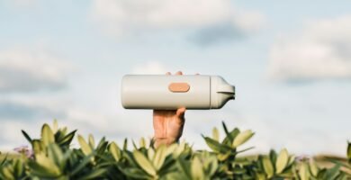 white and black speaker on green plants during daytime